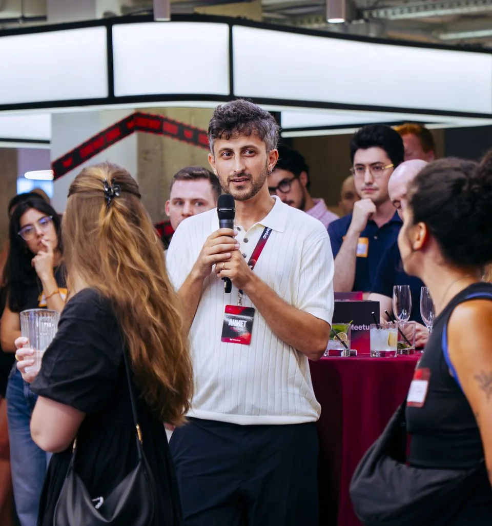 An attendee speaking into a handheld microphone, standing among the others.